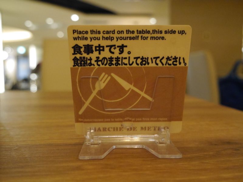 "Don't clean up" card at a food court photo